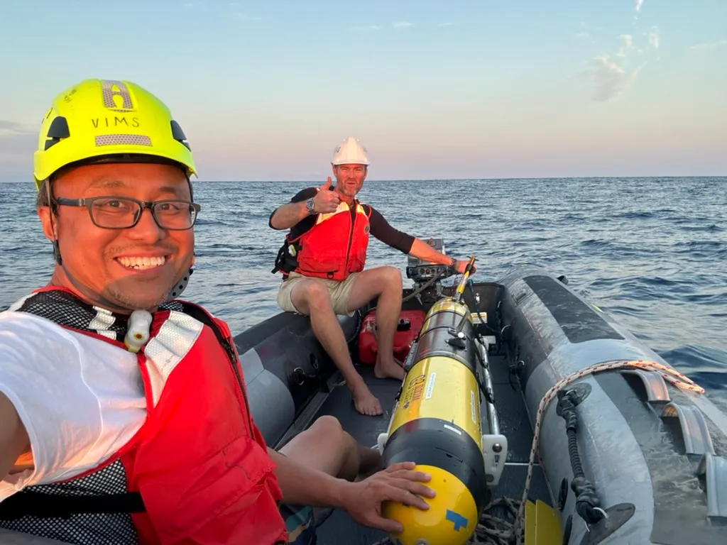 Donglai Gong and a colleague recover a SeaExplorer glider from a small inflatable boat.